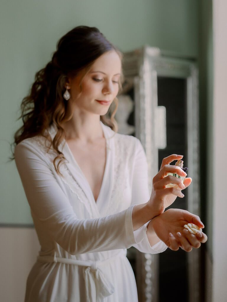 Braut sprüht Parfüm auf - Hochzeit Schloss Machern