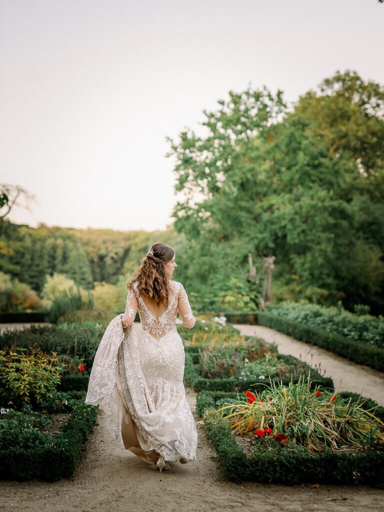 Braut zwischen den Blumenbeten - Hochzeit Schloss Machern